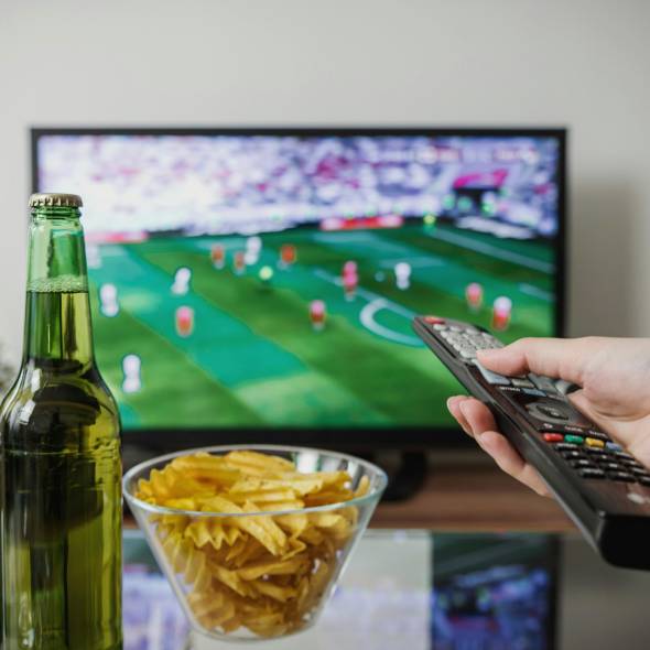Personnes regardant la télévision en direct avec une télécommande